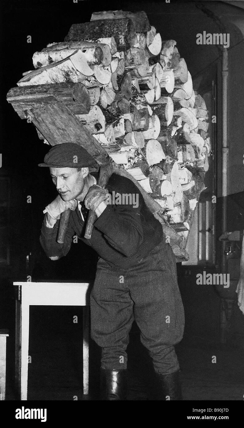 FL3177, KP6107; Mann trägt Bündel Holz Stockfoto