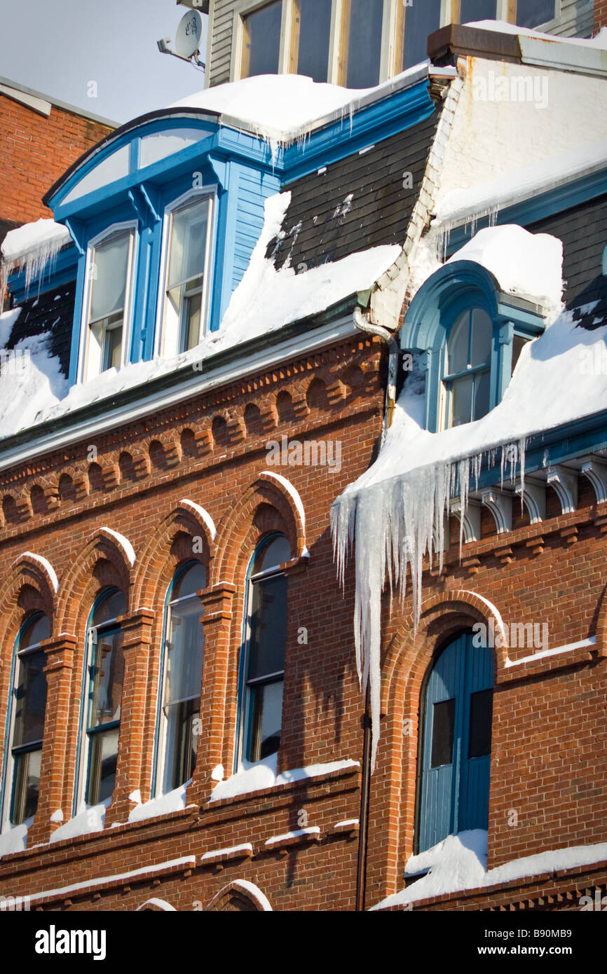 Eiszapfen hängen von der Vorderseite des Gebäudes in der Innenstadt von Portland, Maine. Stockfoto