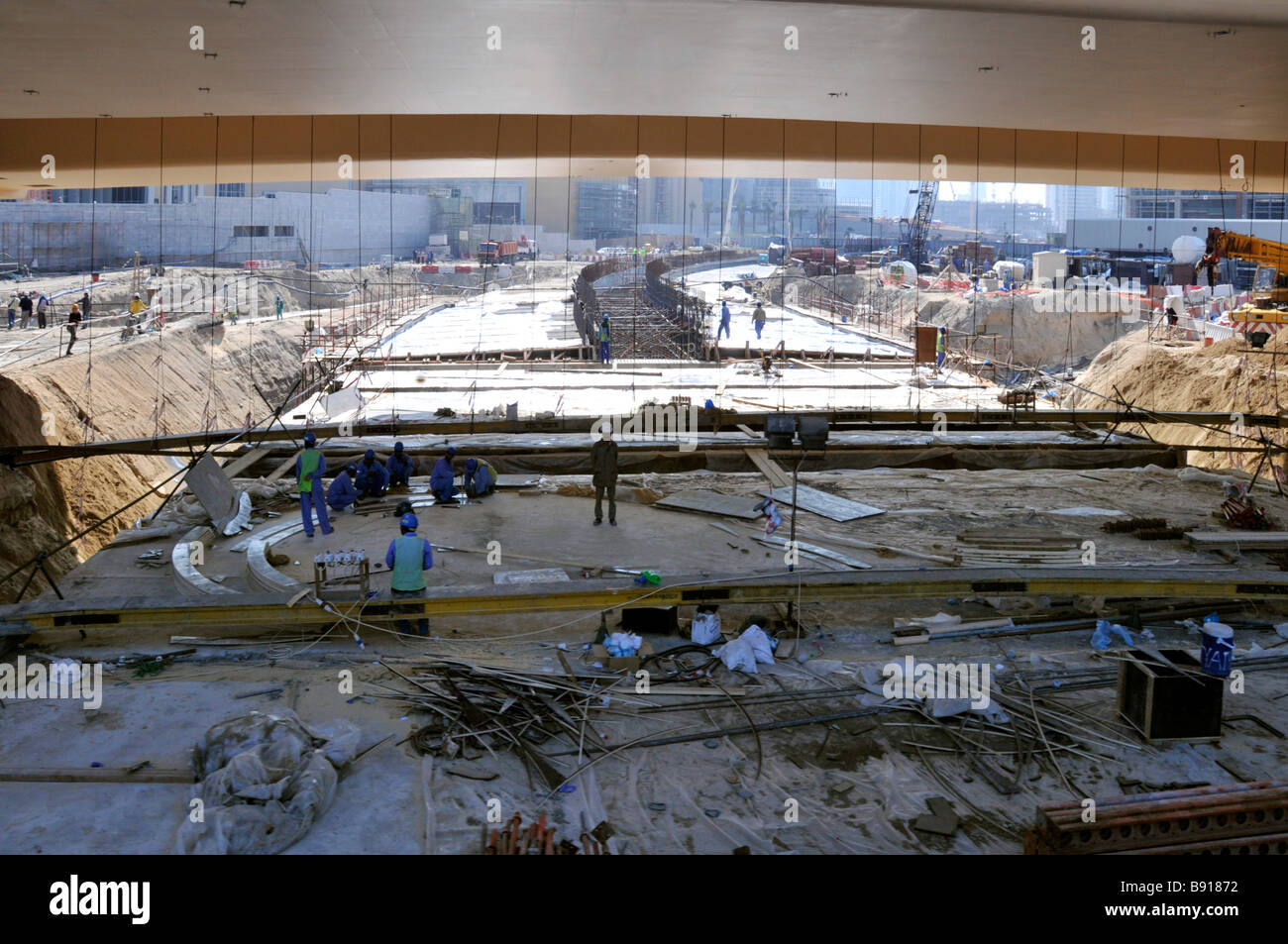 Dubai Dual Fahrbahn Infrastruktur Straßenbau Baustelle Arbeiter in Schatten unter der neuen U-Bahn-Viadukt Vereinigte Arabische Emirate Asien Stockfoto