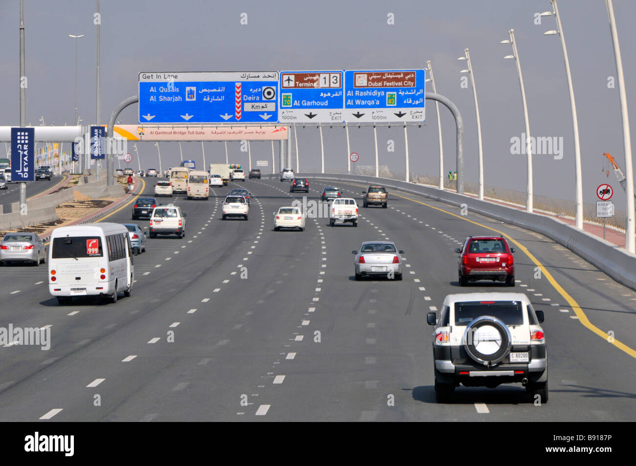 Dubai Autos & Verkehr Fahren auf sieben Spuren Autobahnen & Blaue Wegweiser zu den Flughafenterminals 1 und 3 Vereinigte Arabische Emirate VAE Naher Osten Stockfoto