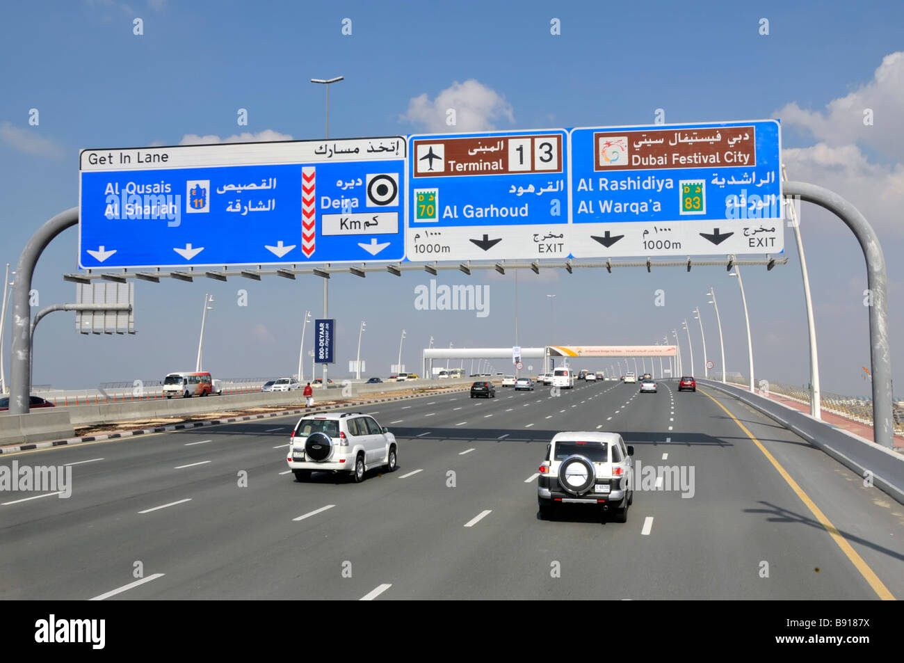 Dubai Autos & Verkehr Fahren auf sieben Spur Autobahn & Blaues Gantry-Schild, das zu den Flughafenterminals 1 und 3 führt Vereinigte Arabische Emirate VAE Naher Osten Stockfoto