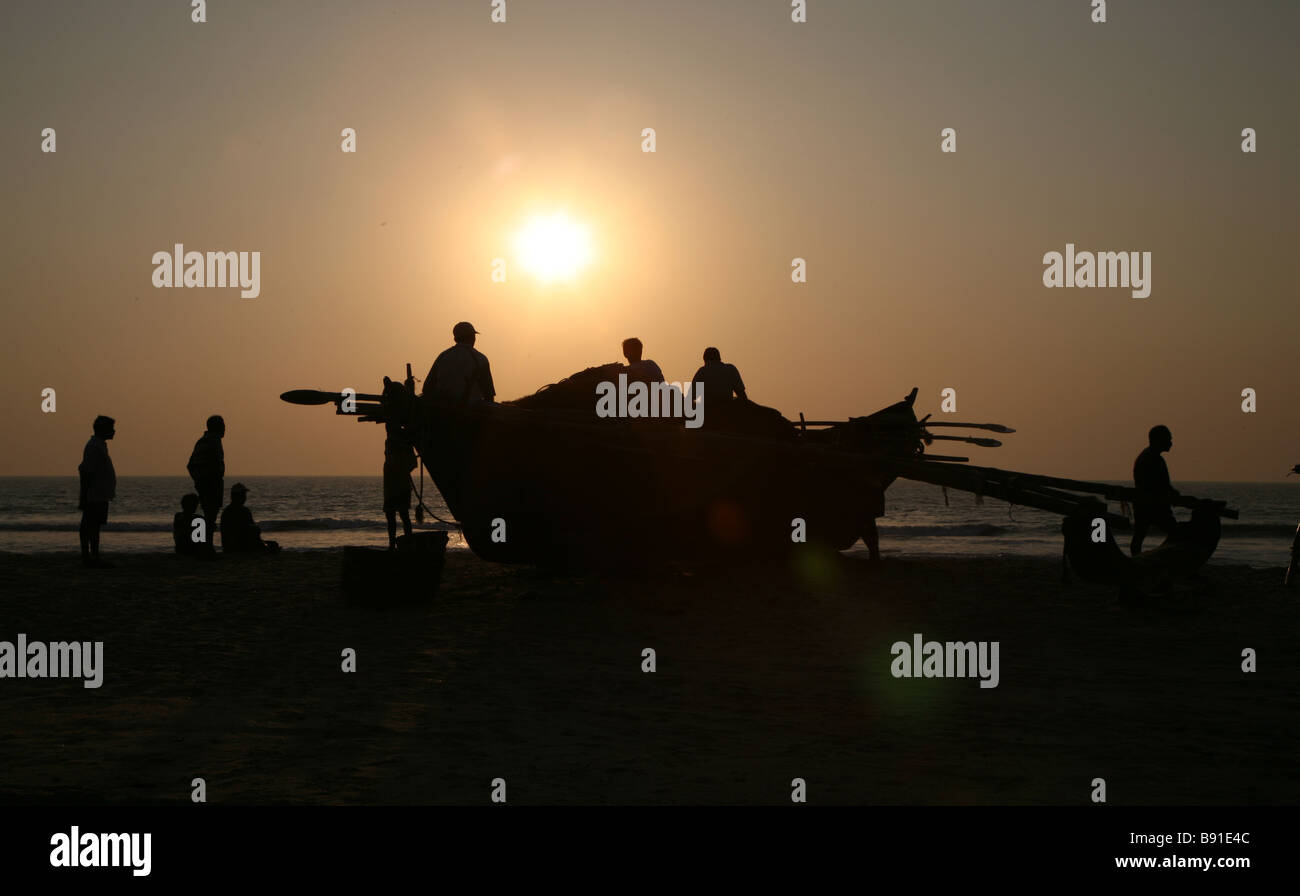 Entspannende Fischer auf Mobor Beach bei Sonnenuntergang in Mobor in Goa, Indien. Stockfoto