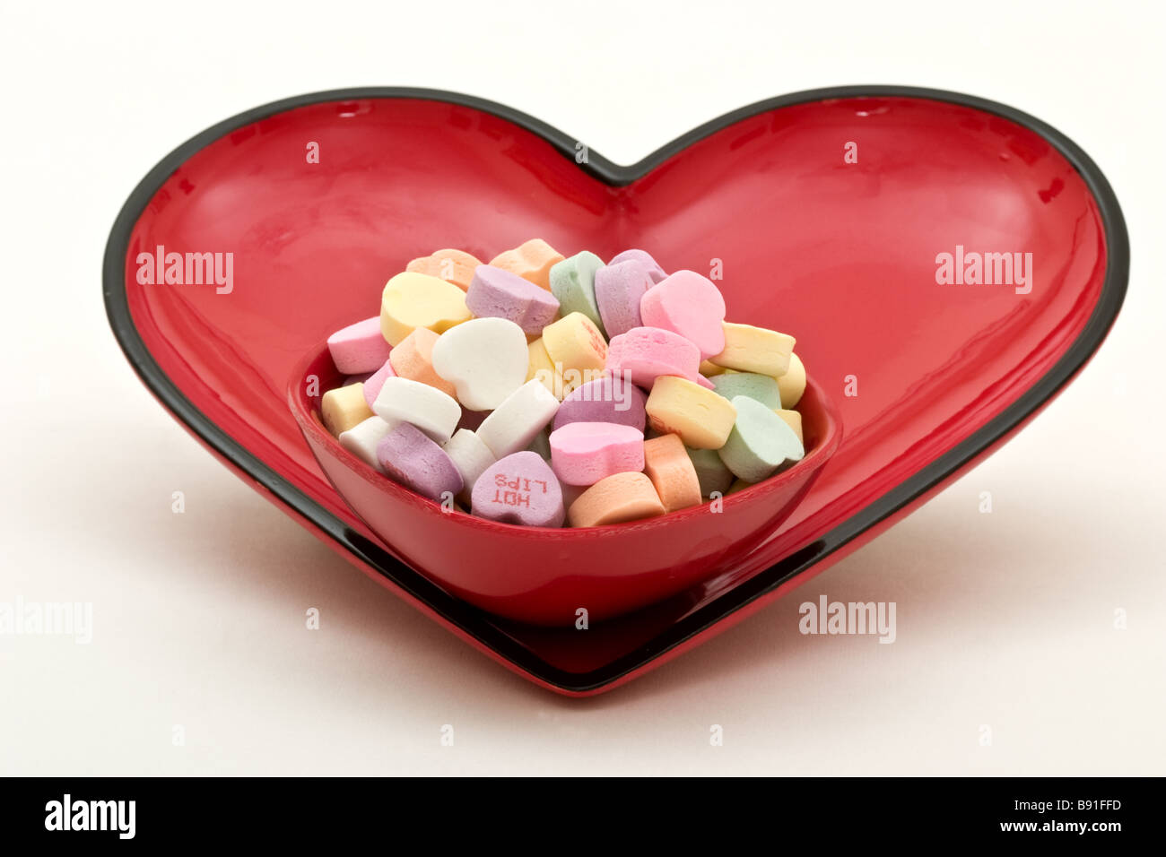 Kleines Bonbon Schüssel gefüllt mit Süßigkeiten in einen größeren Teller herzförmigen Bonbons in Herzform Stockfoto