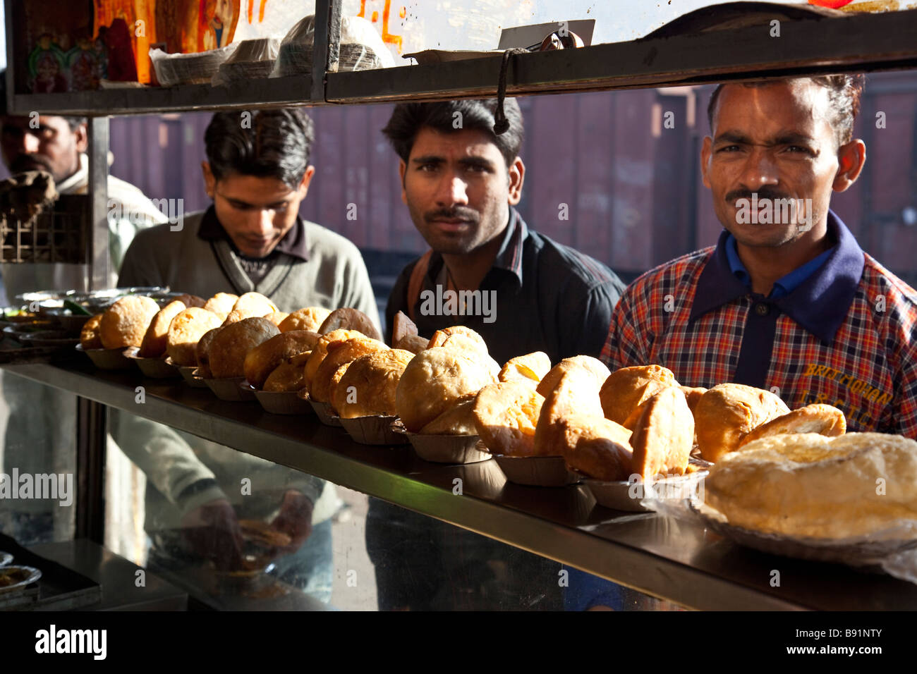 Indische Männer an einem gebratene Nahrung Wagen am Bahnhof in Agra Indien Stockfoto