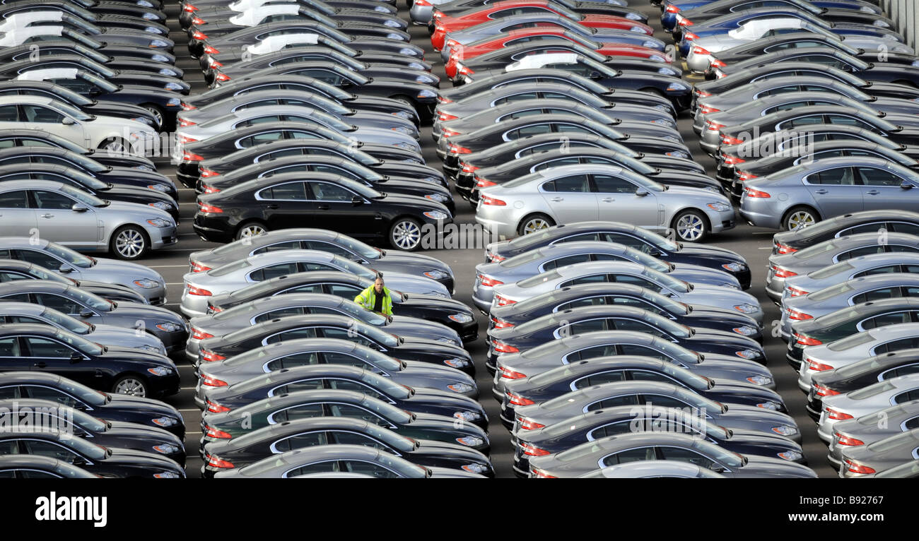 EIN ARBEITER GEHT UNTER DEN BRANDNEUEN JAGUAR AUTOS AN FIRMEN AUTOFABRIK IN CASTLE BROMWICH, BIRMINGHAM, VEREINIGTES KÖNIGREICH. Stockfoto