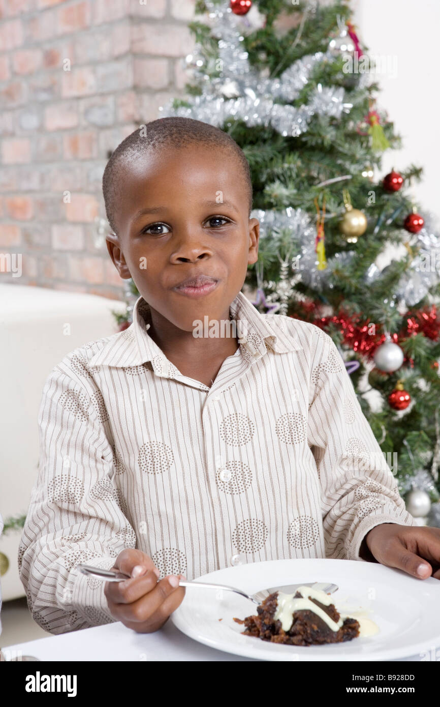 Junge mit einem Mund voller Christmas pudding Stockfoto