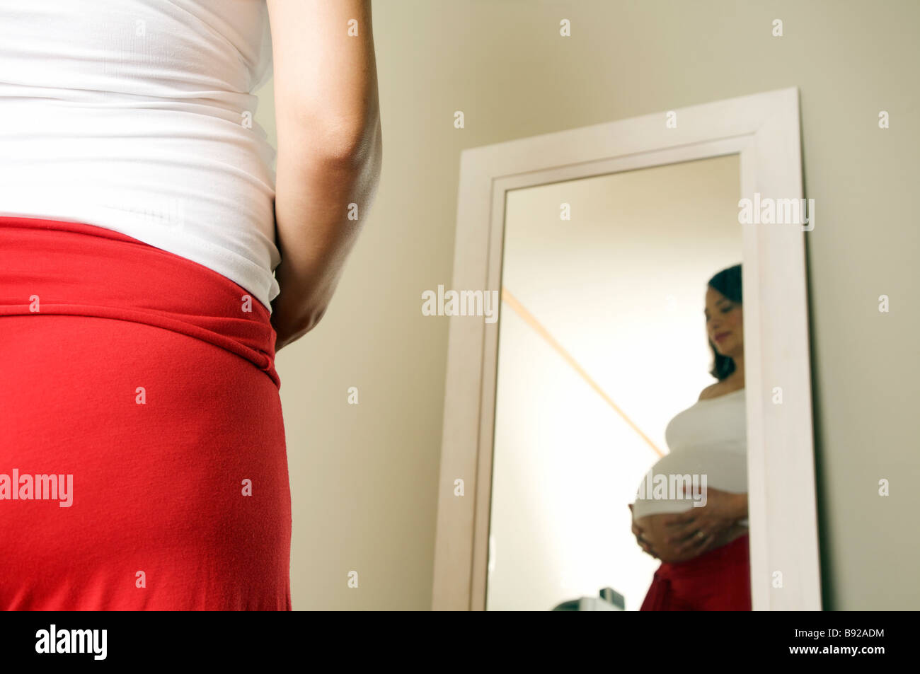 Schwangere Frau Blick auf ihr Spiegelbild in den Spiegel Kapstadt Western Cape Provinz in Südafrika Stockfoto