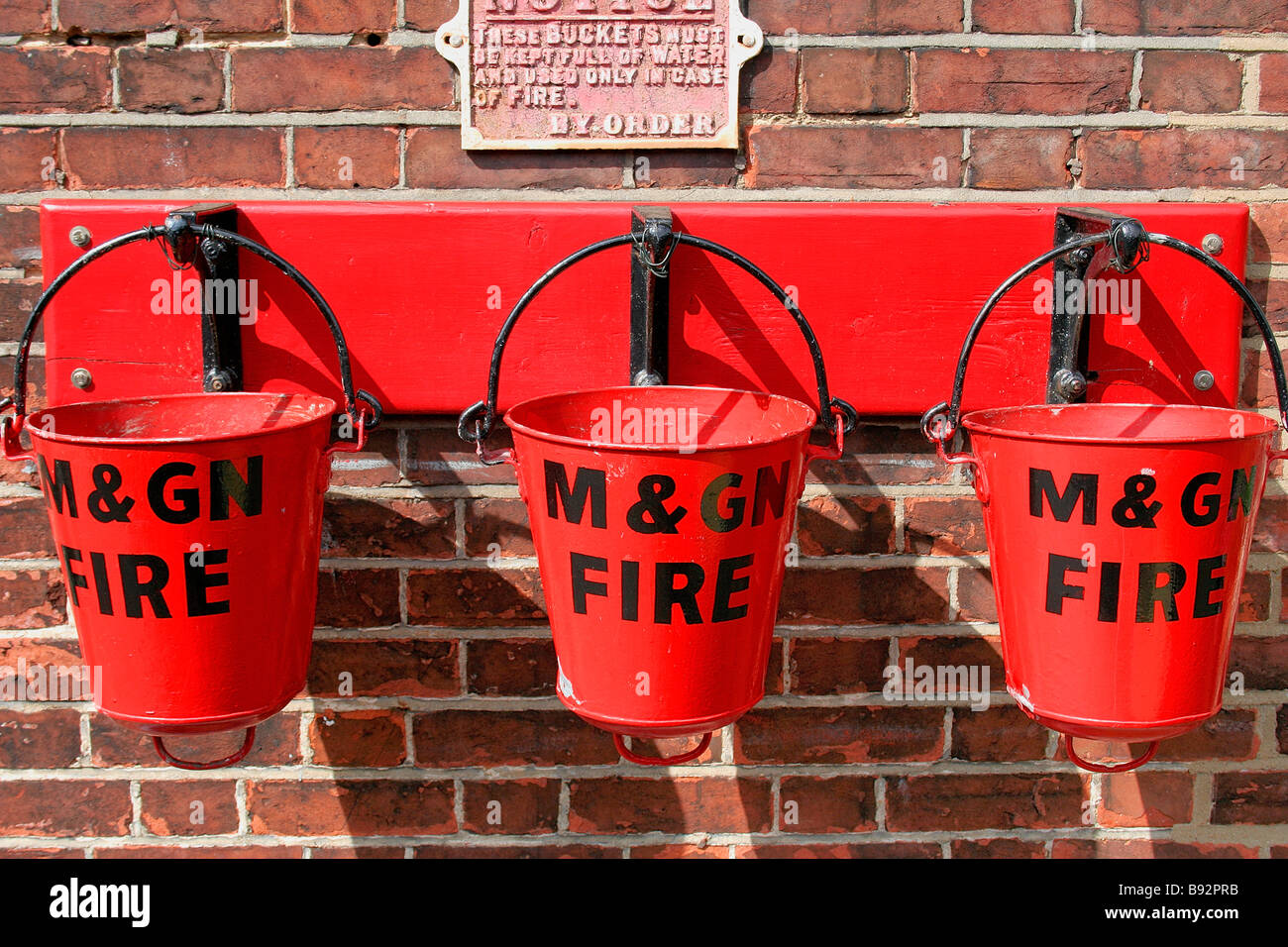 Rotes Feuer Eimer am Holt Station Mohn Linie North Norfolk County England UK Stockfoto