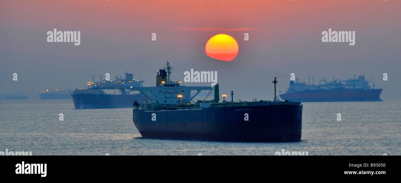 Sonnenuntergang und Schifffahrt einschließlich unbeladener Massengutfrachter und Öltanker Küstenanker der Vereinigten Arabischen Emirate Fujairah Bunkerhafen Golf von Oman in der Nähe der Straße von Hormuz Stockfoto