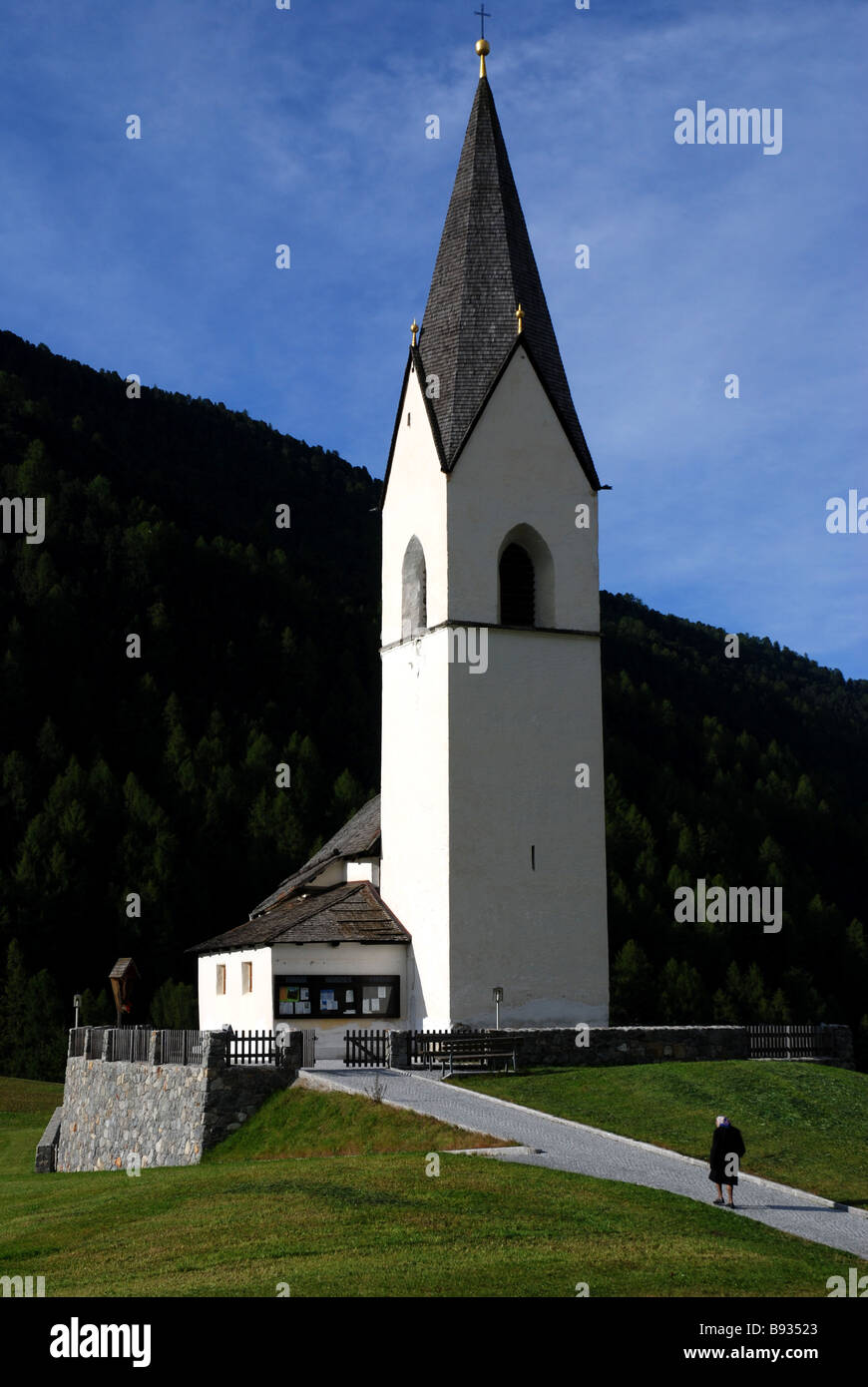 Alte Frau zu Fuß zur Kirche in Langatauferntal Lanmgtaufernvalley Süd Tiroler Alpen Südtirol Italien Stockfoto