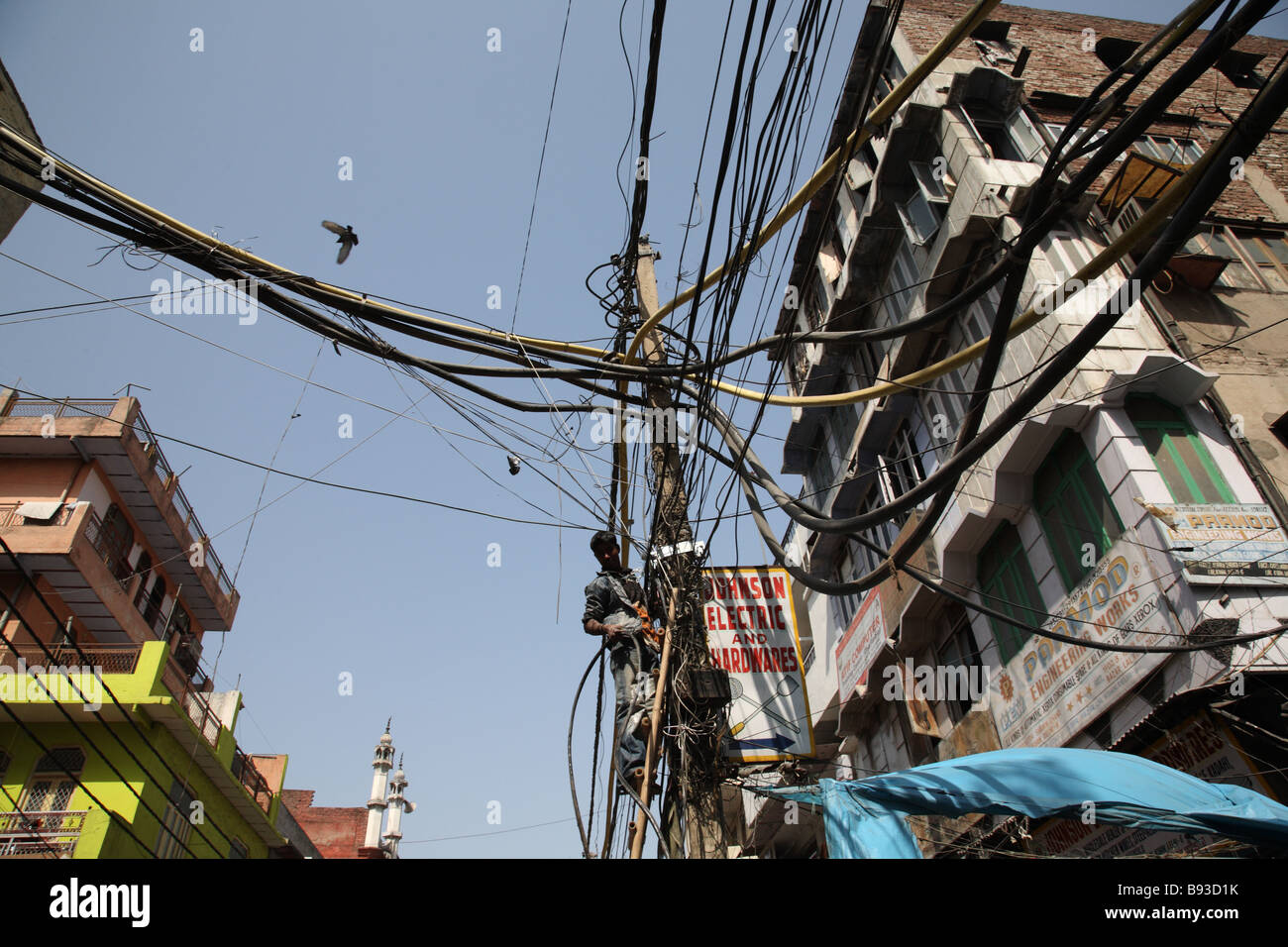 Elektriker repariert Kabel an einem Mast in der Straße in Alt-Delhi, Indien. Stockfoto