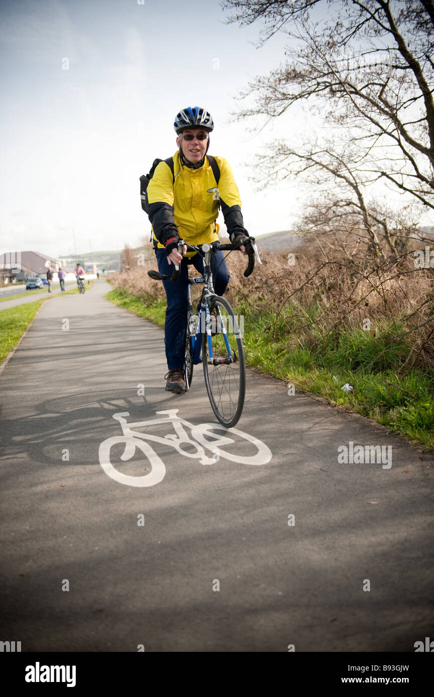 Ein Mann Person das Tragen eines Helmes, Radfahren auf dem dedizierten Rheidol Trail-Radweg Aberystwyth Wales UK an einem Frühlings-Nachmittag Stockfoto