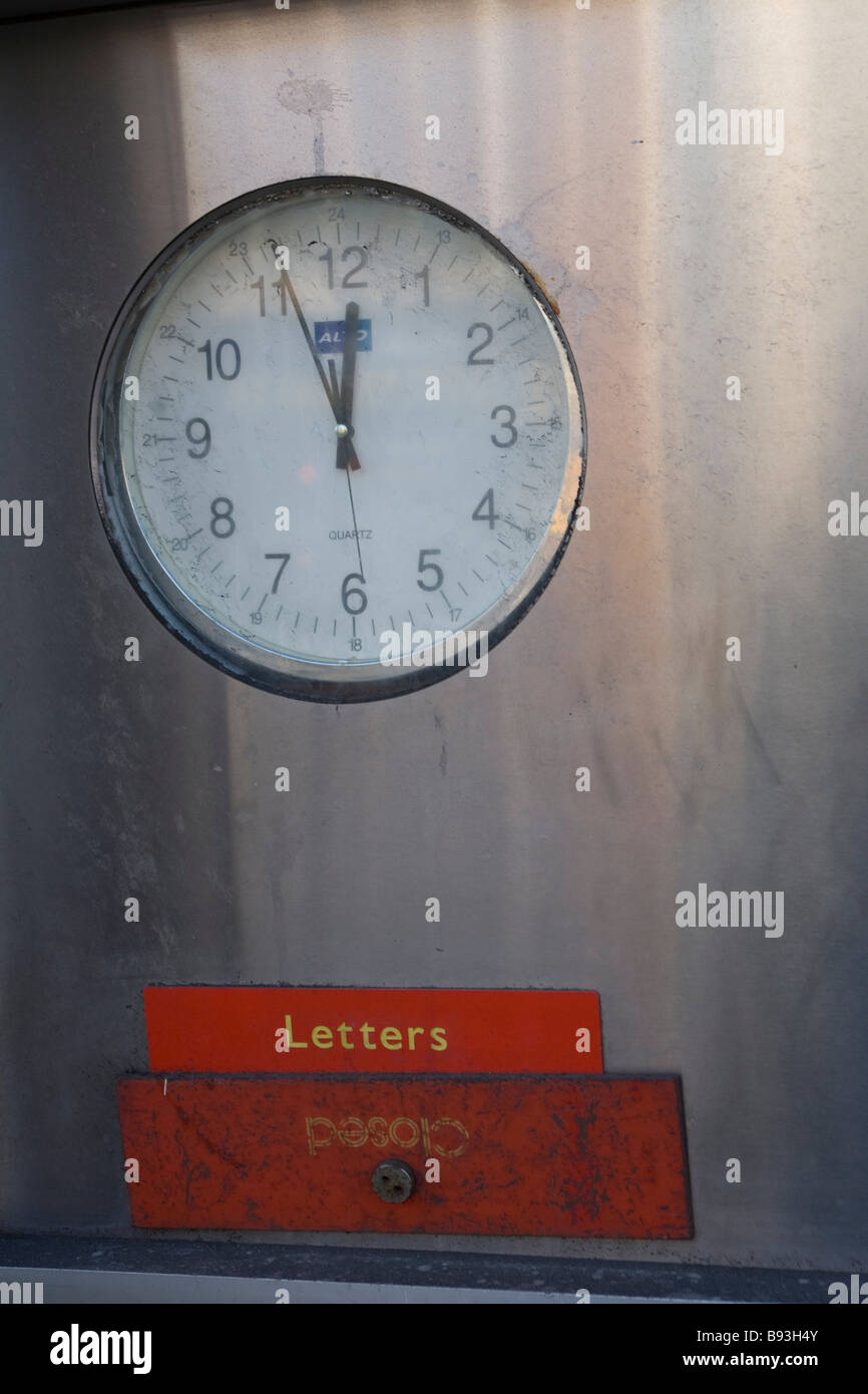 A versiegelt Briefkasten mit einer Uhr oben an der Vorderseite der kürzlich stillgelegten Postamt Stockfoto