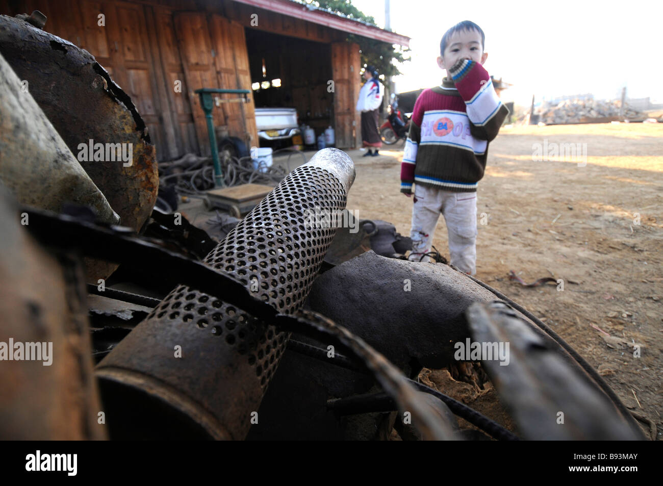 Ein kleiner Junge vor seinem Haus, wo seine Eltern aus Metall Jäger in Phonsavan Laos Bombe Schrott kaufen Stockfoto