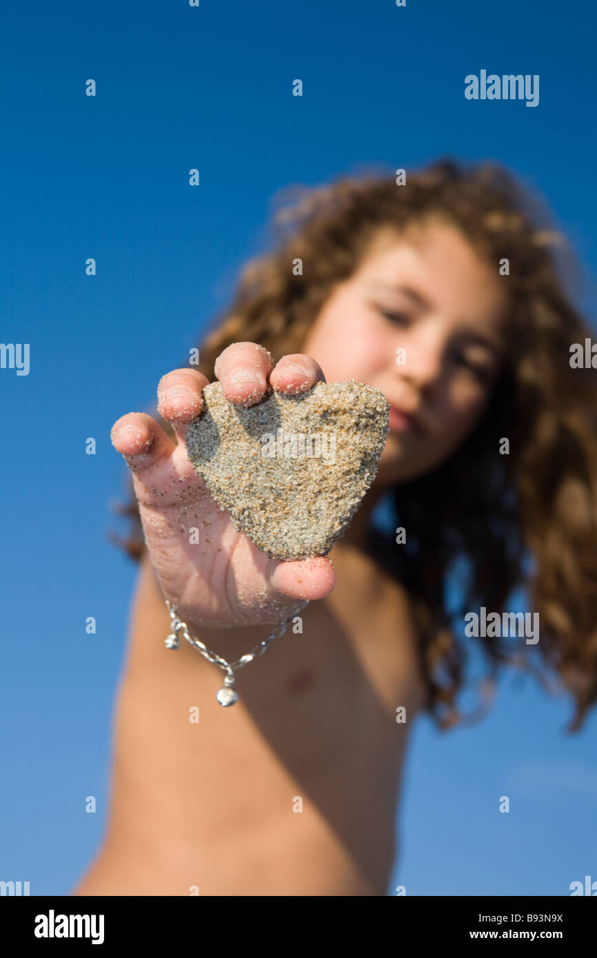 Kind zeigt Stein mit einer Herzform. Stockfoto
