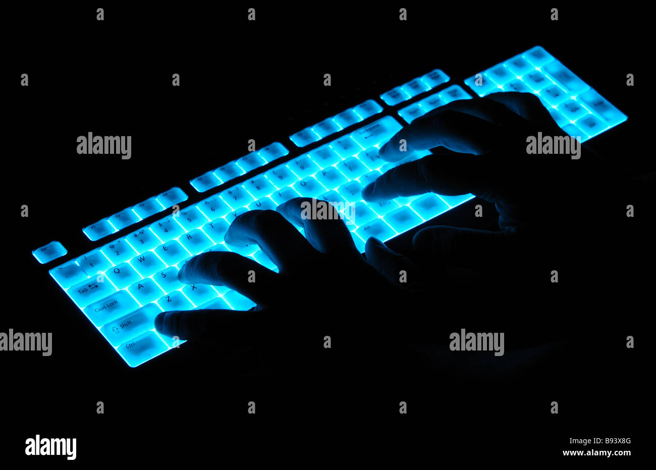 Hände über leuchtende Tastatur Stockfoto