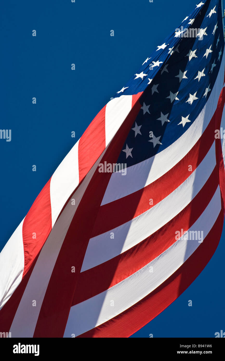 Vereinigten Staaten Amerika Flagge bekannt als Stars And Stripes wehen im Wind vor blauem Himmel Stockfoto
