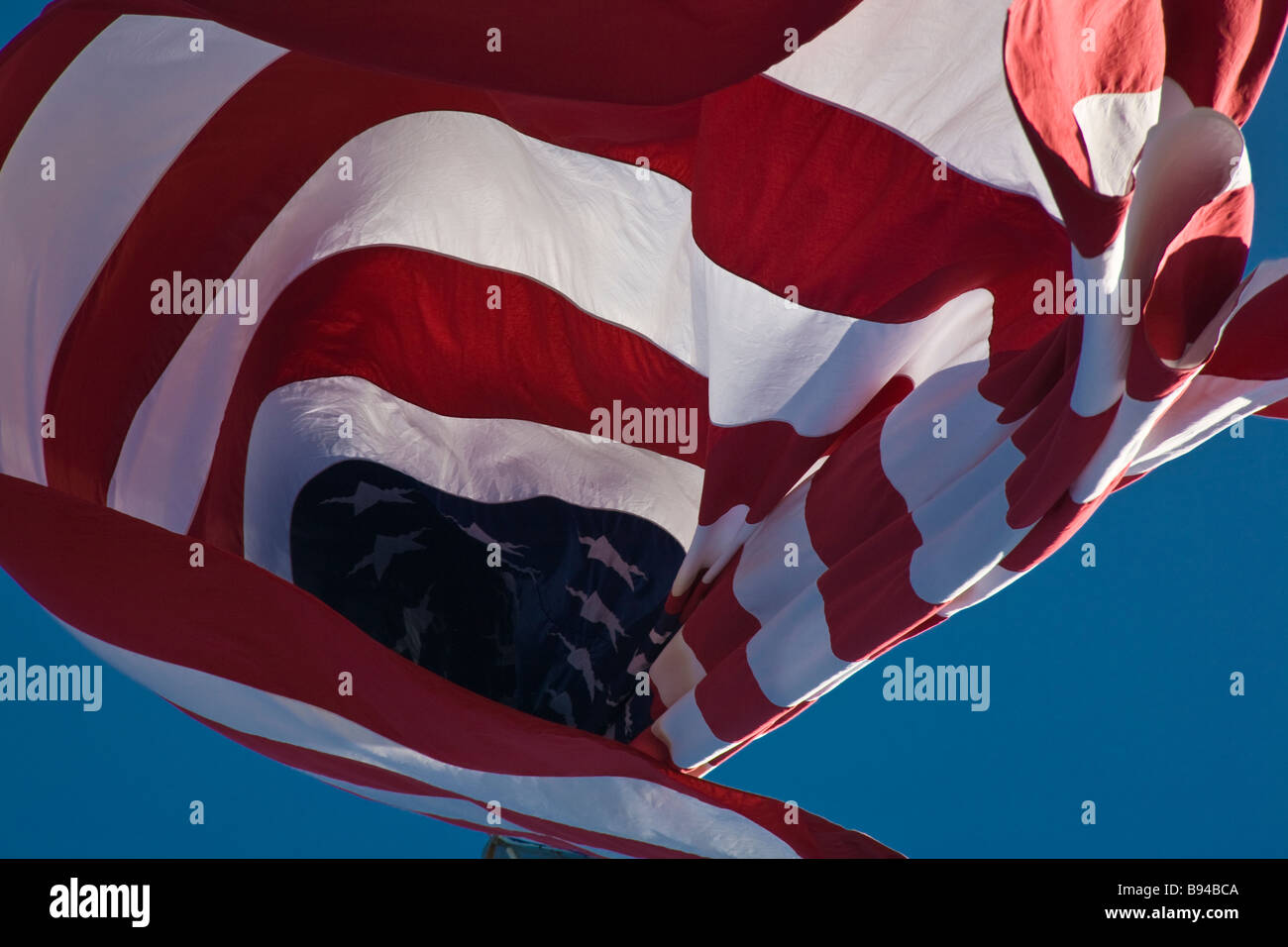 Vereinigten Staaten Amerika Flagge bekannt als Stars And Stripes wehen im Wind vor blauem Himmel Stockfoto