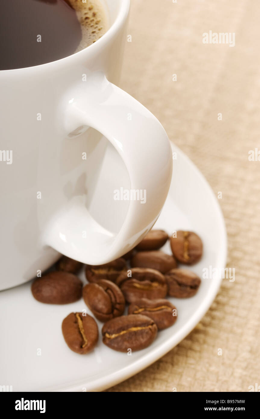 Nahaufnahme der Tasse schwarzen Kaffees und Bohnen in einer Untertasse Stockfoto