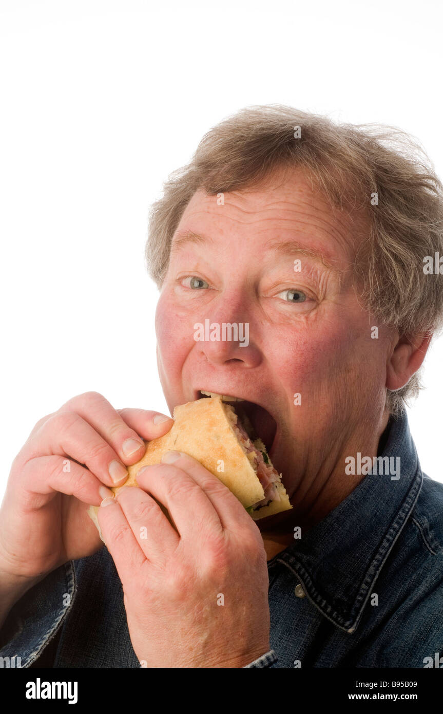 Senior Mittelalter Mann isst große Gourmet-Salamibrot mit Ciabatta-Brot Stockfoto