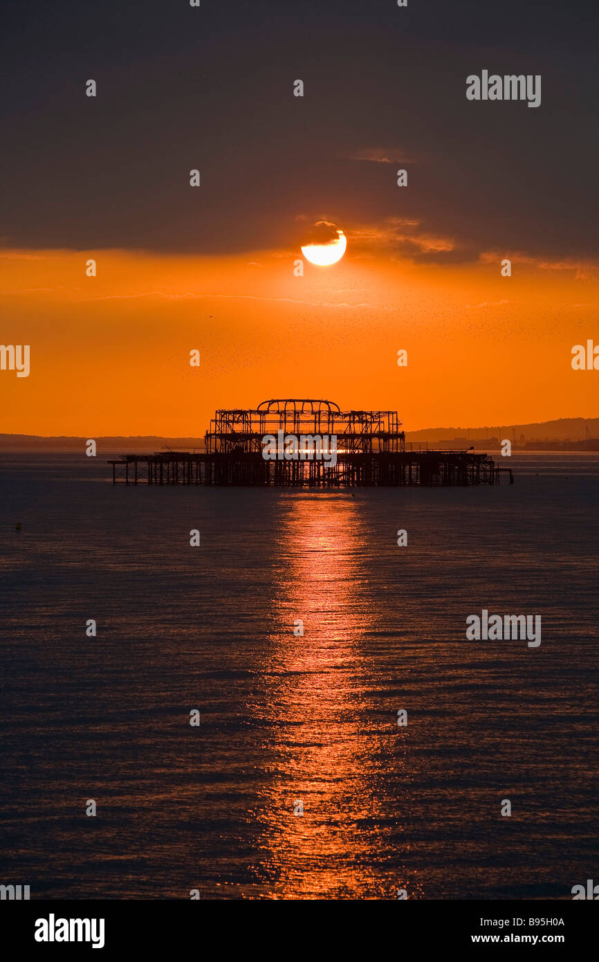 ENGLAND East Sussex Brighton bleibt der West Pier Silhouette gegen eine Orange-rote Sonnenuntergang Stockfoto