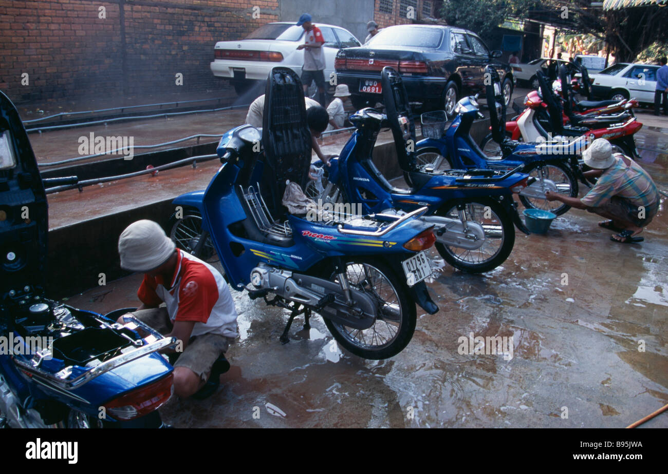 Kambodscha Siem Reap in der Nähe von Angkor Wat Motorräder und Autos, die mit der lokalen roten Feinstaub von ihnen gewaschen. Stockfoto