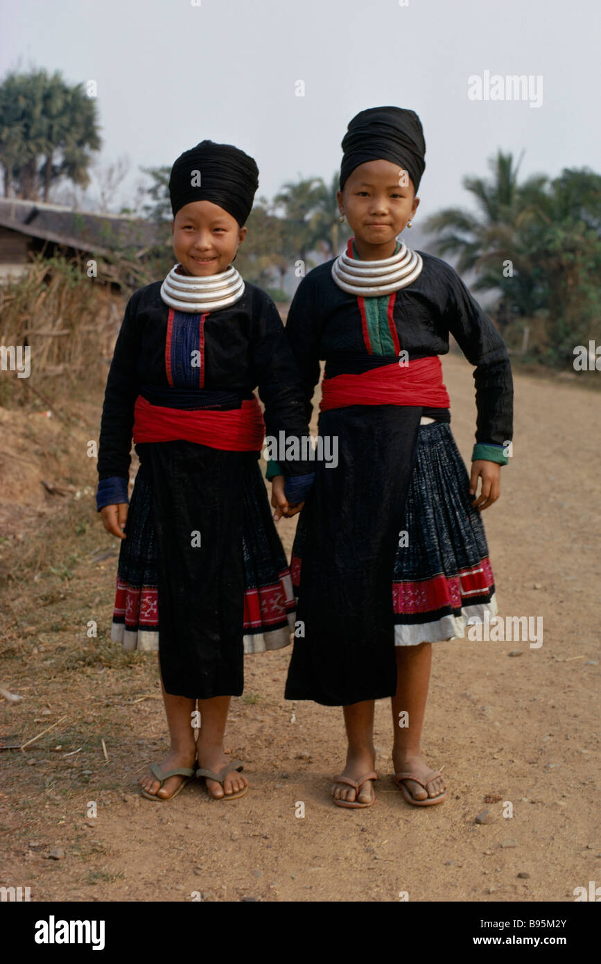 LAOS Südostasien Stammes-Leute Meo Stamm Porträt zweier Mädchen Hand in Hand lächelnd in traditionellen Kostümen und Hals Ringe Stockfoto