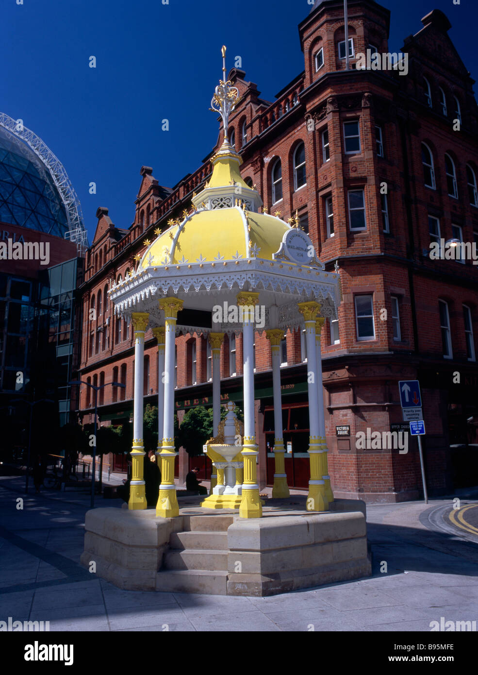 Nordirland, Belfast, Victoria Square.  Gelb und weiß überdachte Jaffe Brunnen mit Backsteinfassade der gebisslose Bar hinter. Stockfoto