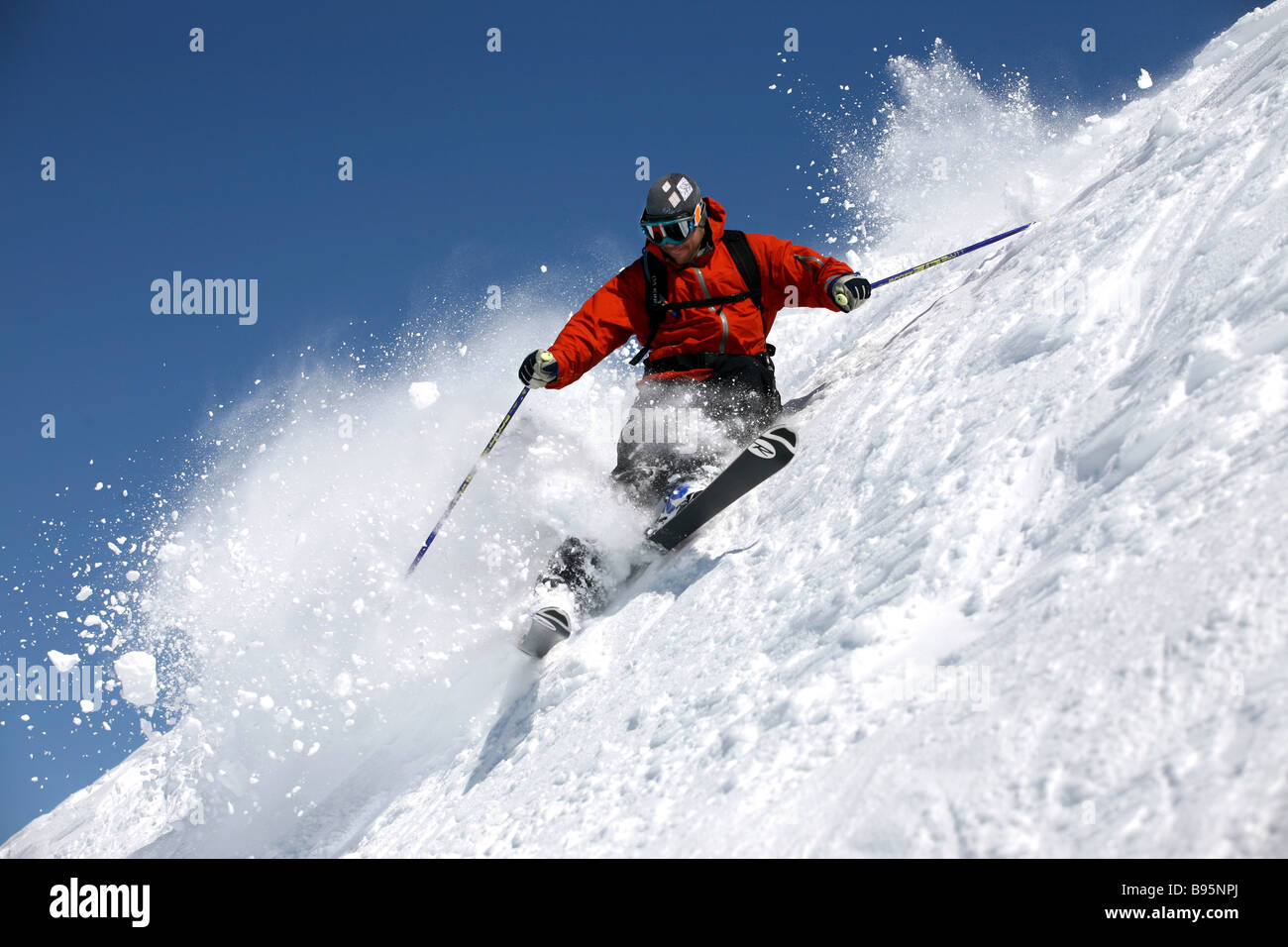 Erfahrene Skifahrer an einem steilen Hang verfolgt Schnee Stockfoto