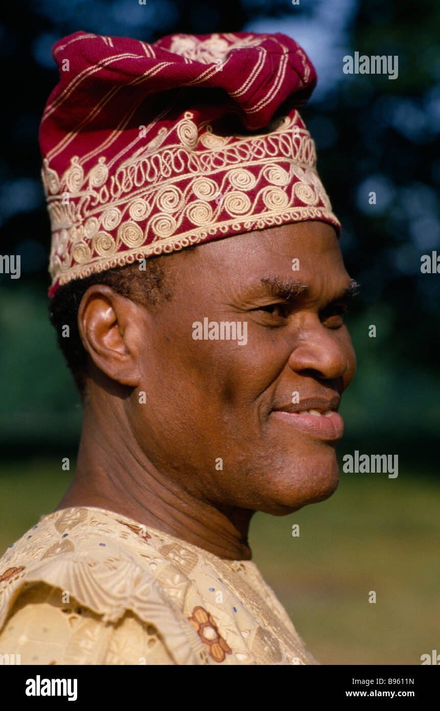 NIGERIA Westafrika Portrait von glücklich lächelnde Yoruba Chief mit Hut und Mantel. Stockfoto