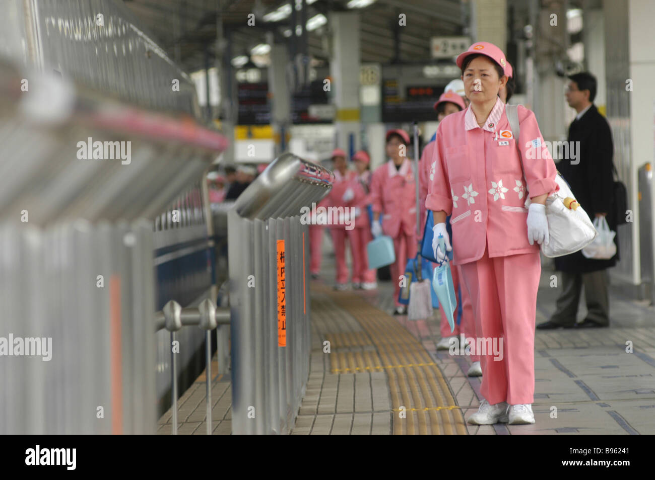 JAPAN Honshu Tokio A Putzkolonne Mitte im Alter von Frauen in uniform warten einen Hochgeschwindigkeitszug Shinkansen zur Reinigung an Bord. Stockfoto