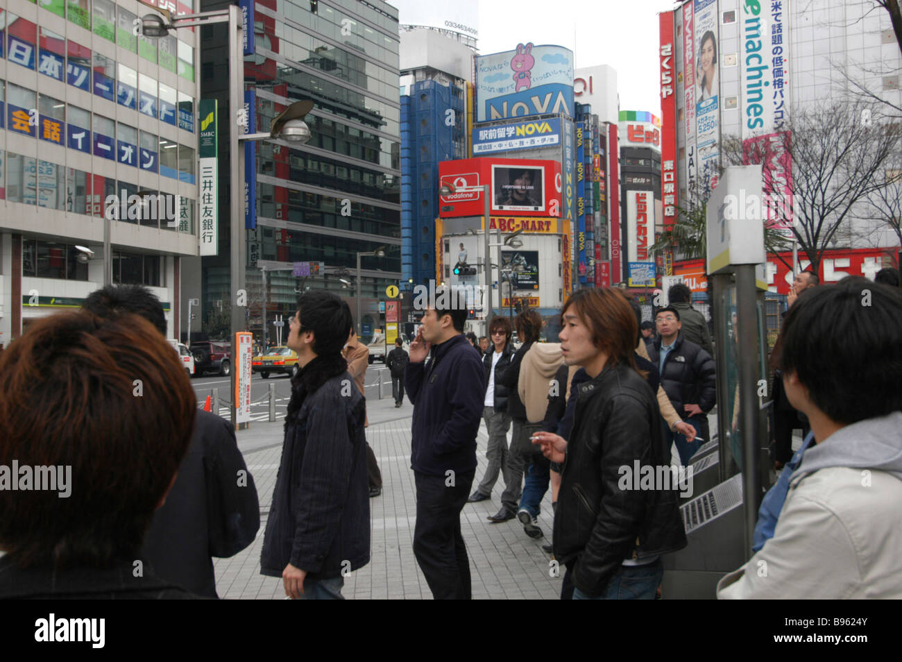 JAPAN Tokyo Shinjuku draußen Shinjuku Station Raucher Leuchten an einer Werbung auf Gebäuden Rauchen-Station. Stockfoto