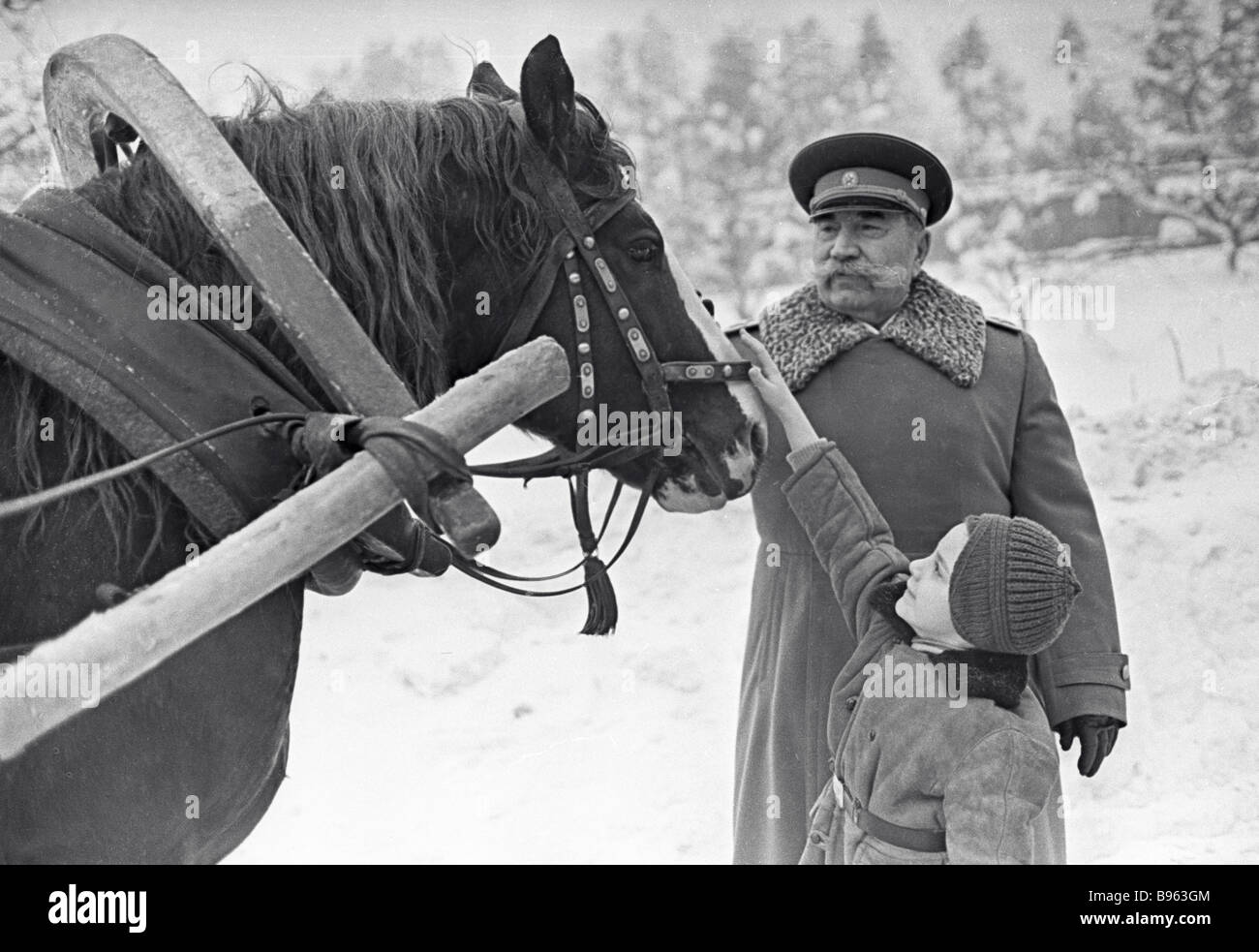 Marschall der Sowjetunion Semjon Budyonny und sein Enkel Aljoscha Streicheln ein Pferd Stockfoto