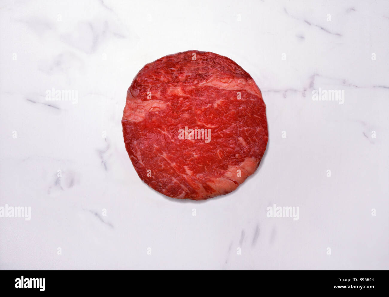 Runde rohes Rindfleisch auf einer Marmorplatte Stockfoto