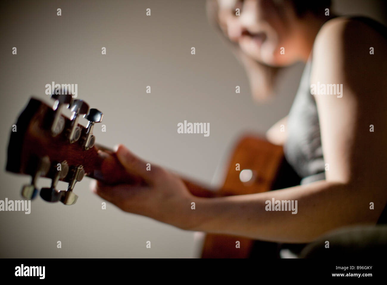 Junge Frau Gitarre spielen Stockfoto