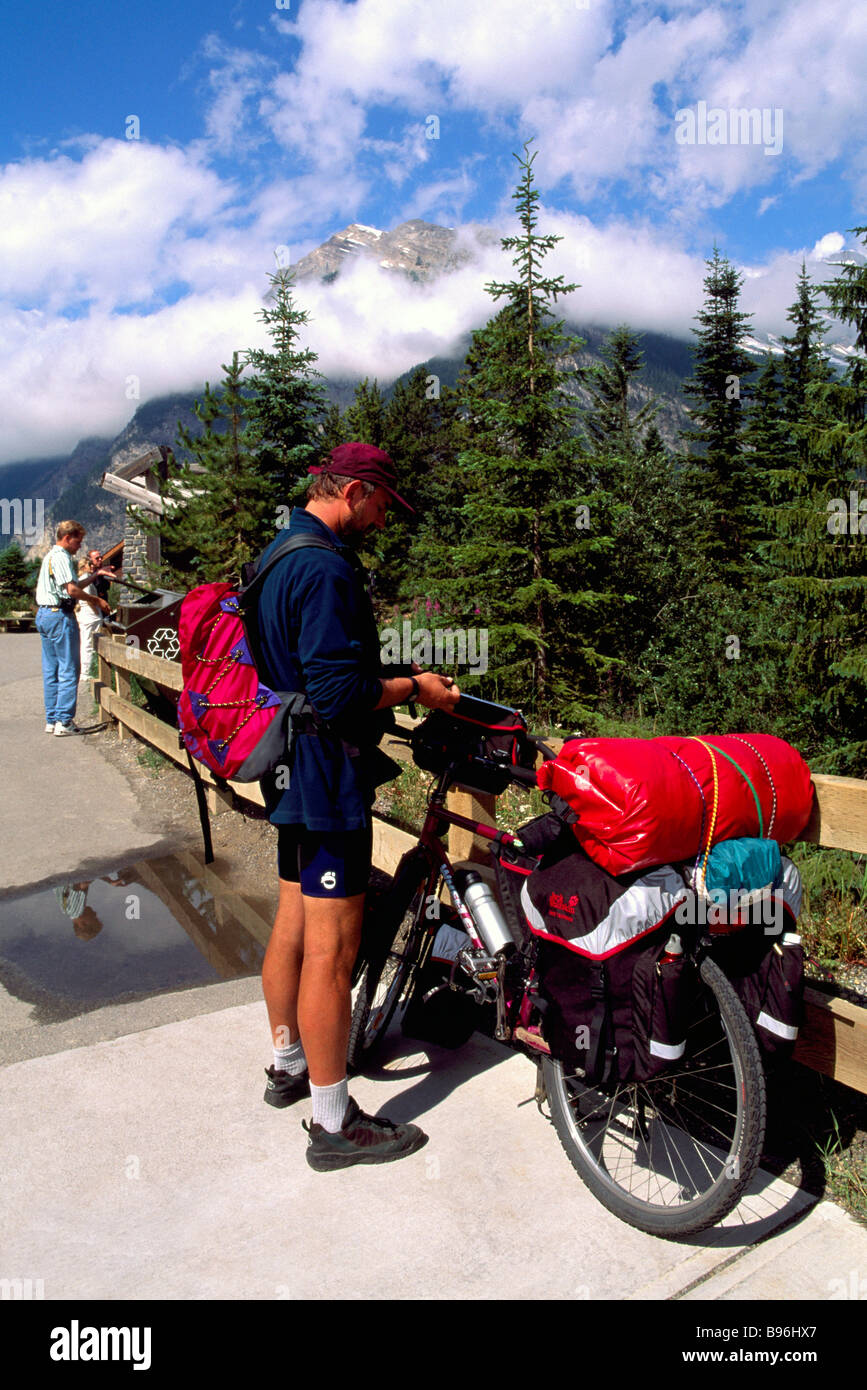 Radfahrer mit dem Fahrrad / Motorrad gepackt mit Taschen und bereit für Touren und Reisen durch Berge und Wald Stockfoto