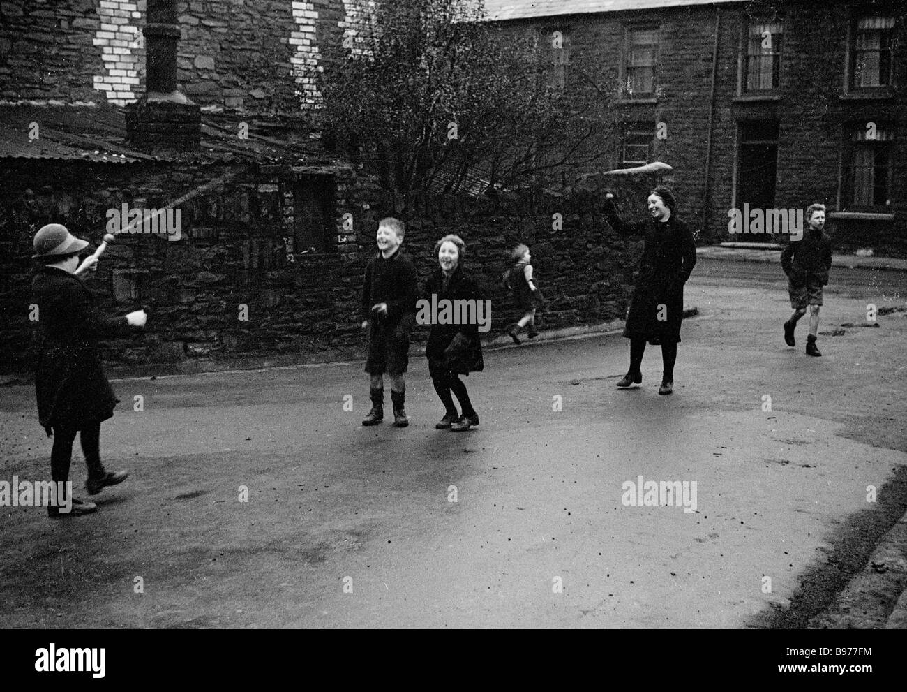 1940s, historische Schulkinder, die in einer nassen Seitenstraße in Trehafod, South Wales, Großbritannien, mit einem Springseil spielen, auf diesem Bild von J Allan Cash Stockfoto