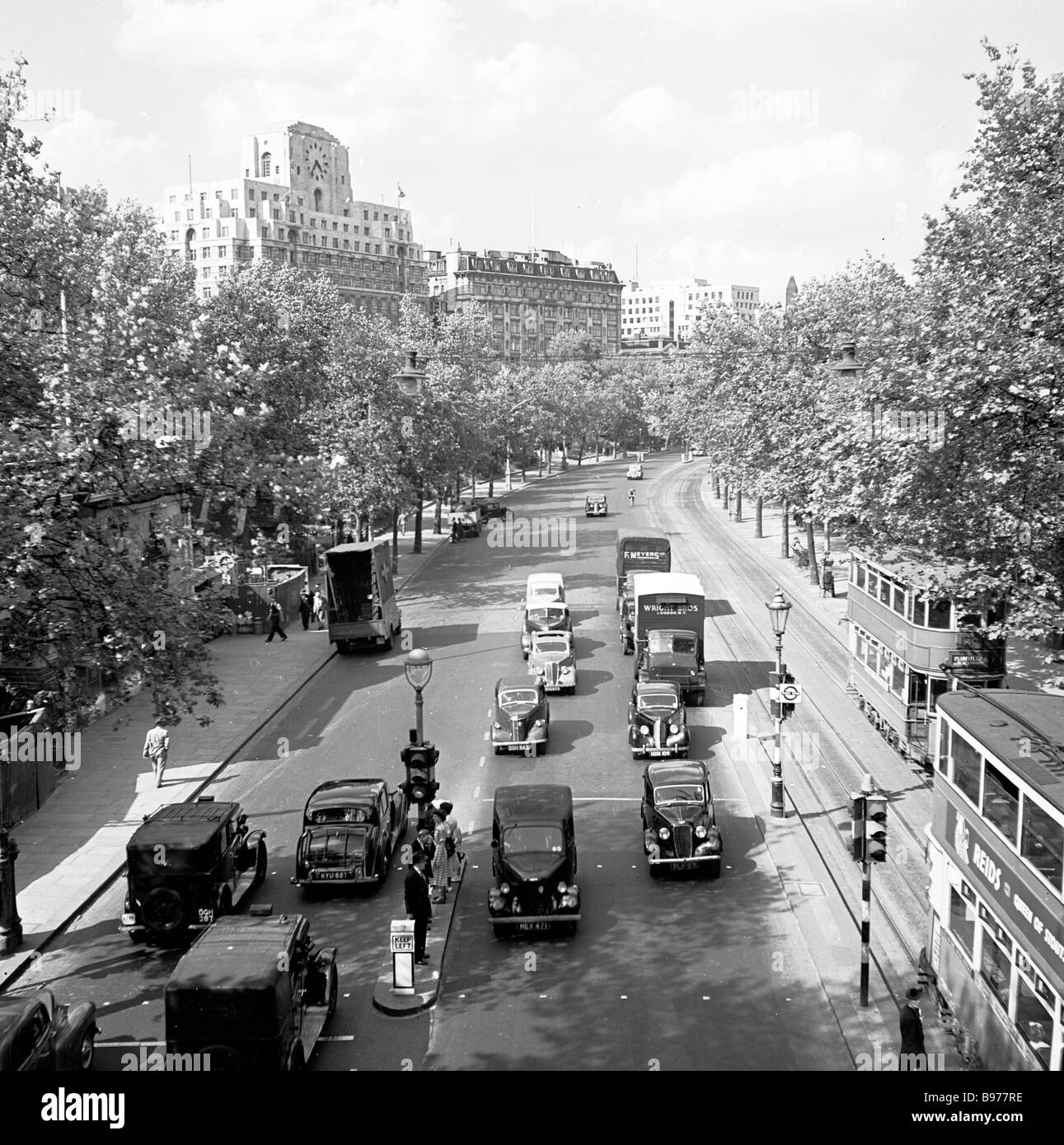 Ansicht von oben auf das Victoria Embankment, London, 1950er Jahre, mit Autos, Lastwagen und Doppelstockbahnen, mit Shell Mex House in der Ferne. Stockfoto