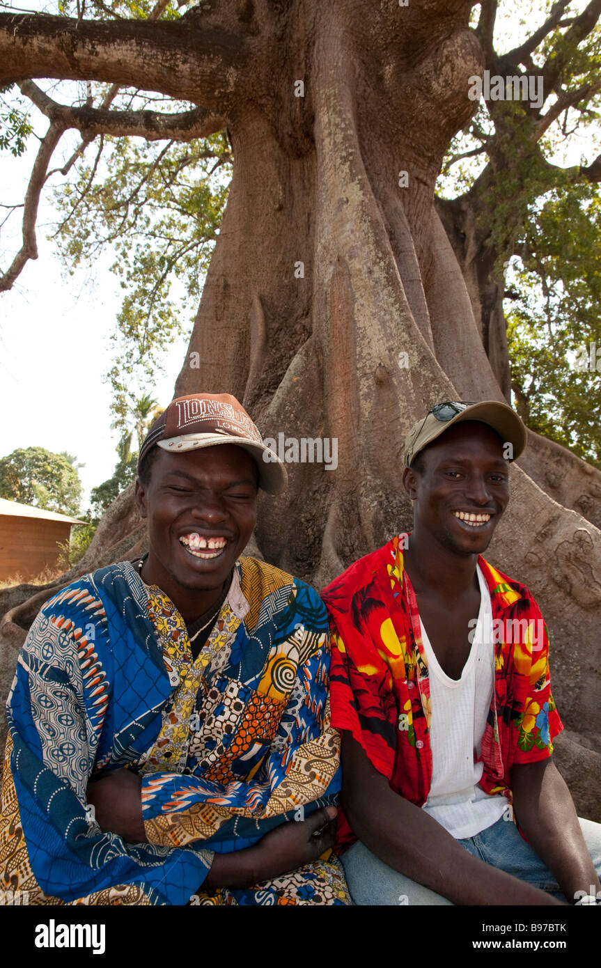 West-Afrika Senegal niedriger Casamance Mlomp Porträt von zwei jungen Männern, die unter einem Affenbrotbaum lachen Stockfoto