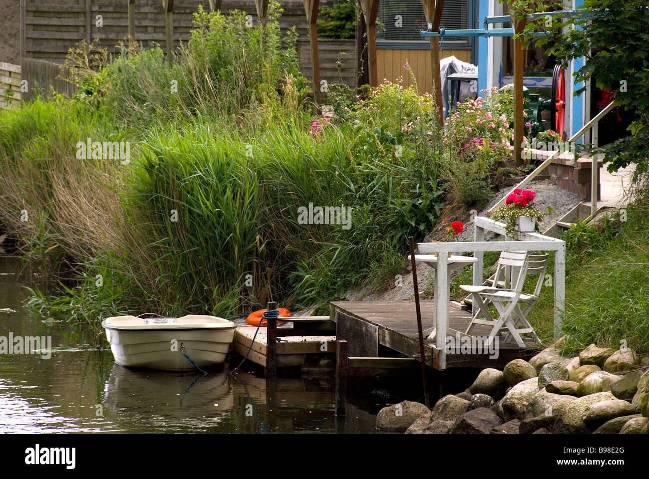 Ein Garten mit Bach und ein Boot drin Jütland Dänemark Stockfoto