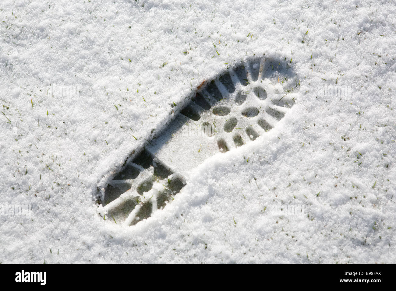 Boot zu drucken (Footprint) in leichter Schneefall auf Rasen Stockfoto