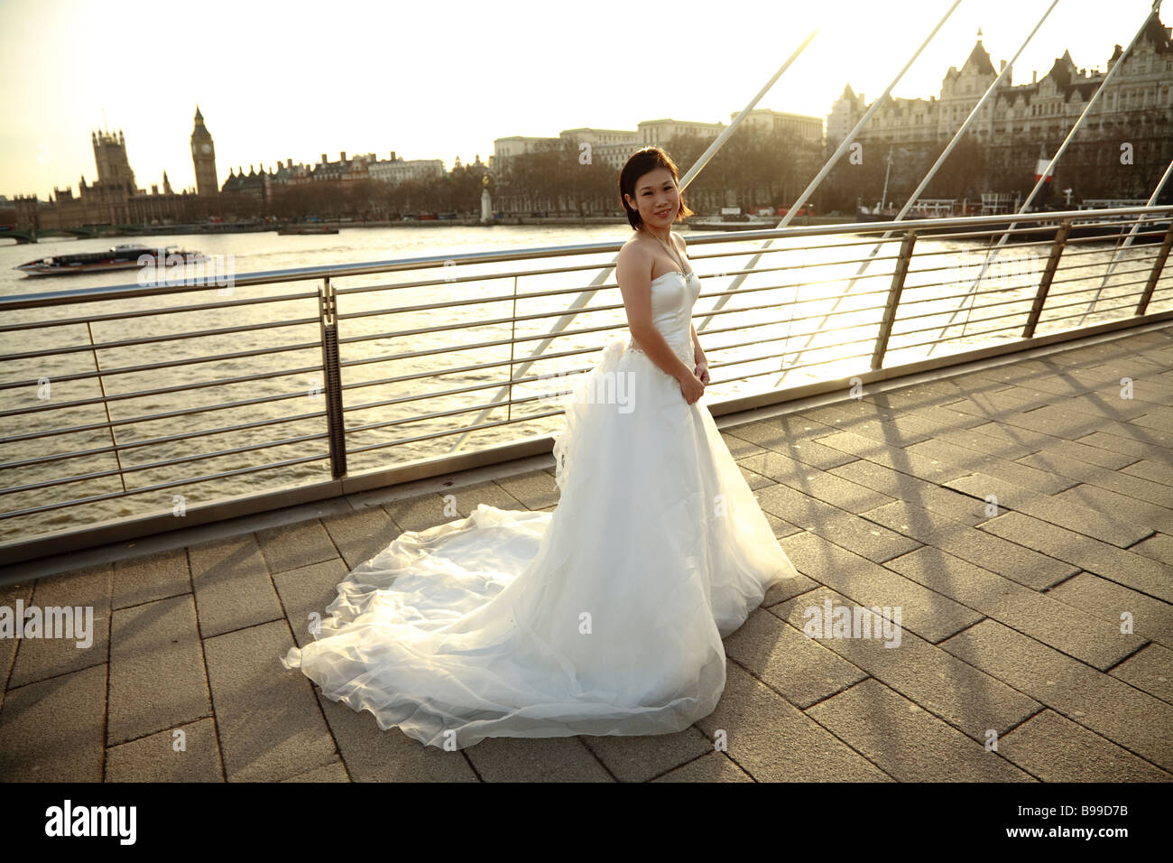 eine asiatische Braut im Brautkleid vor Stadtbild von London, Themse und Westminster mit Big Ben Stockfoto
