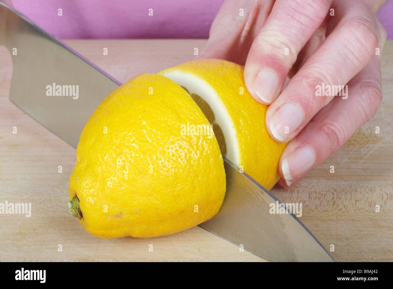 Woman Slicing Lemon Modell veröffentlicht Stockfoto