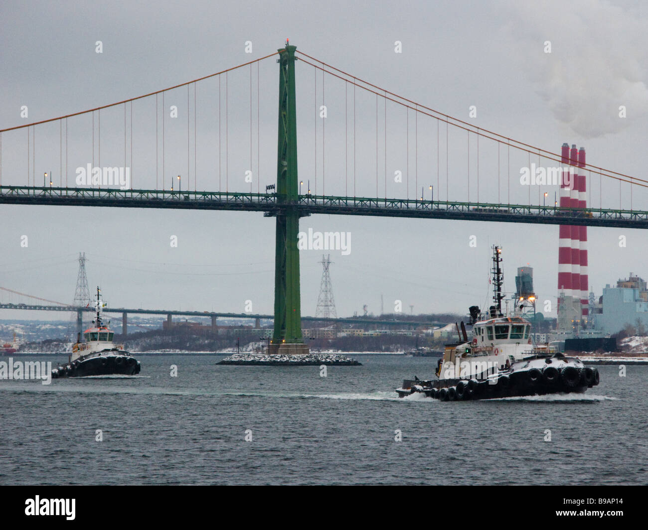 Zwei Schlepper transit Halifax Harbour, Nova Scotia, mit der MacDonald-Brücke im Hintergrund. Stockfoto