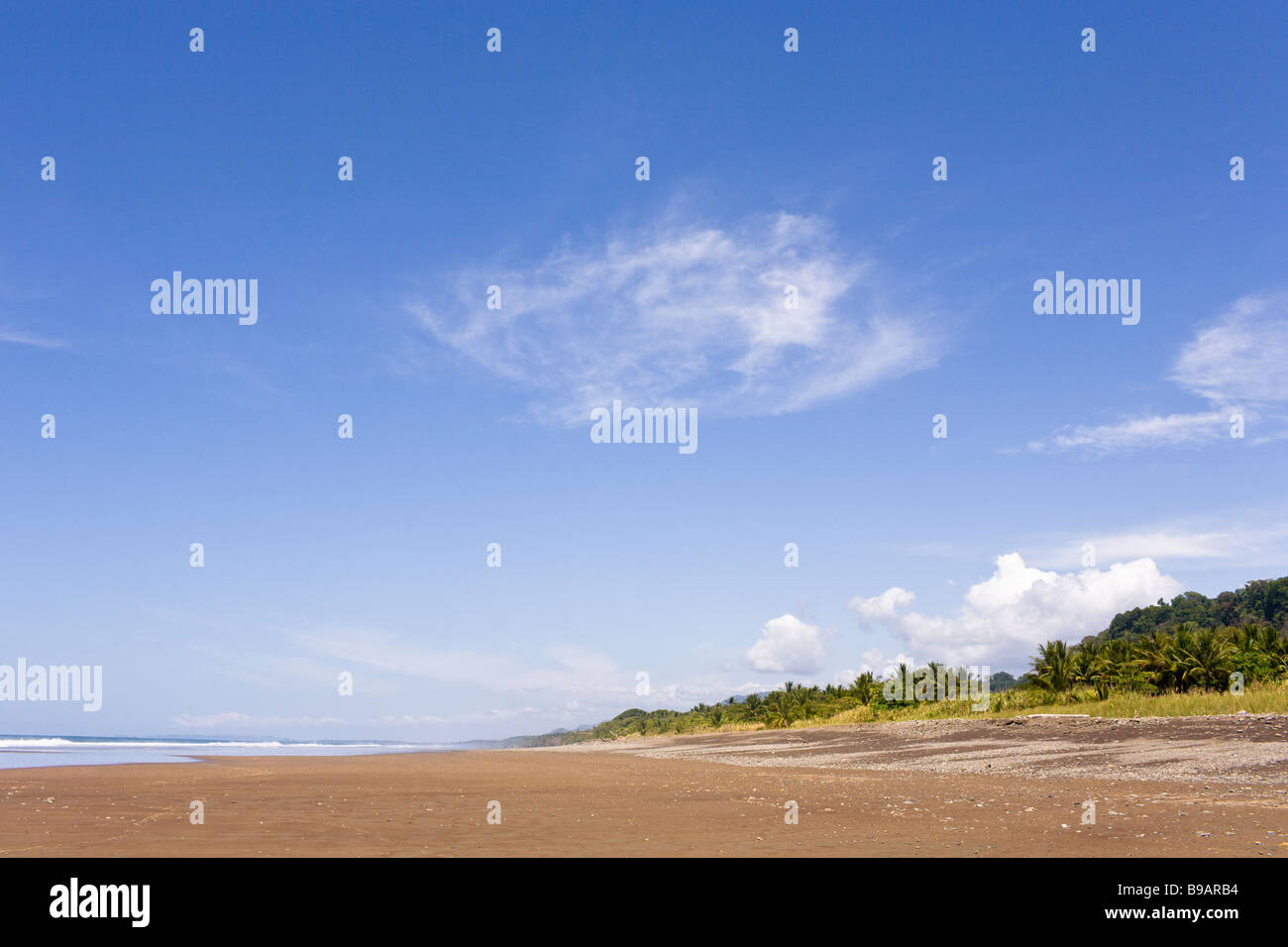 Verlassener Strand mit tiefblauen Himmel in Playa Dominical, Costa Rica. Stockfoto