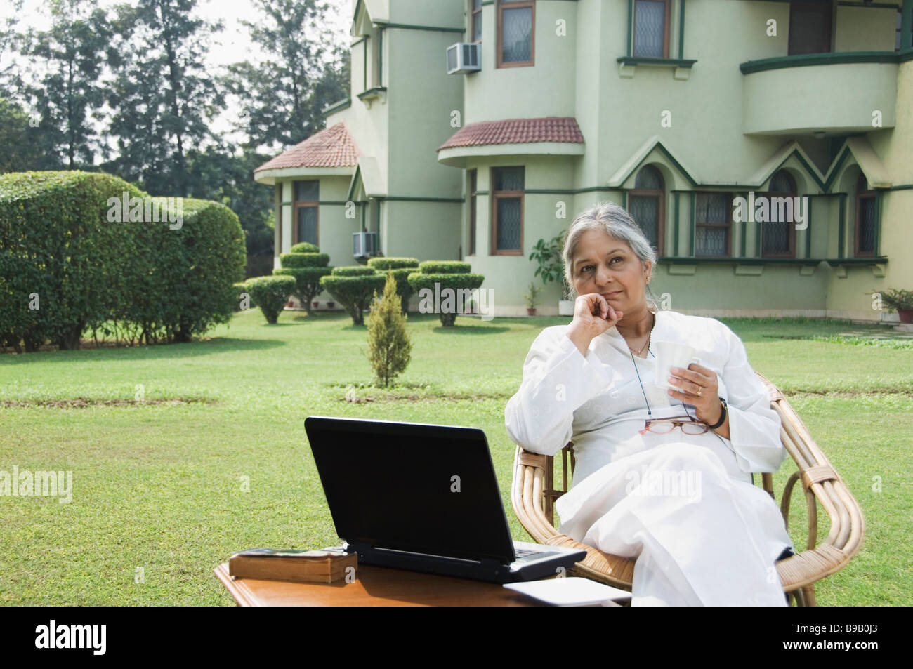 Frau mit einem Laptop in einem Rasen, New Delhi, Indien Stockfoto