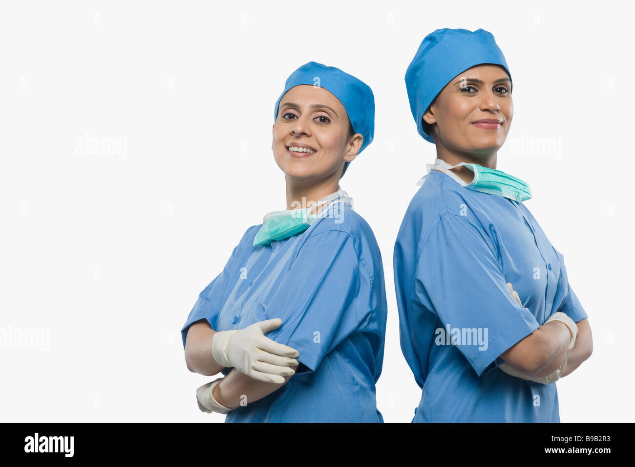Porträt von zwei weiblichen Chirurgen lächelnd Rücken an Rücken Stockfoto