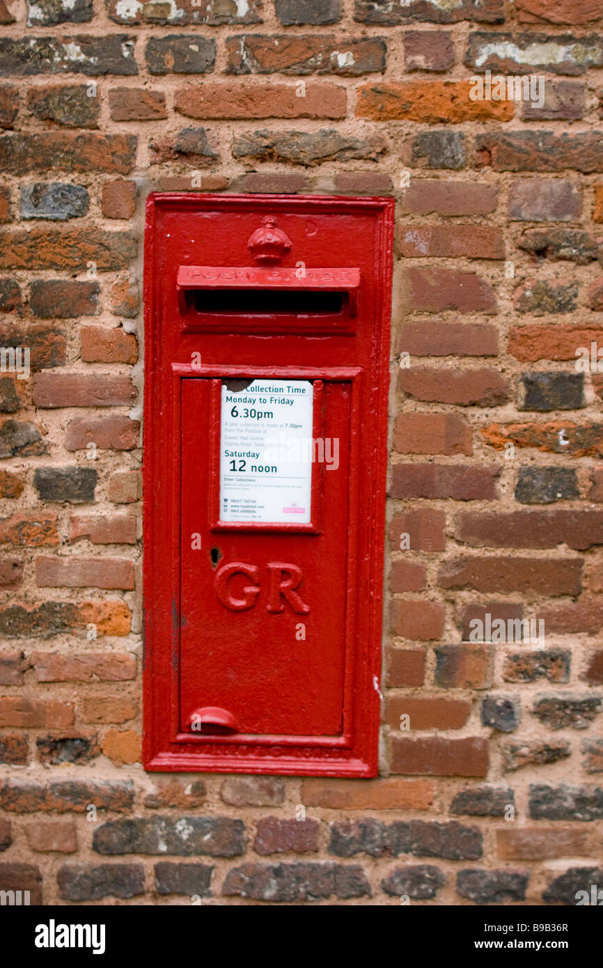 Roten Briefkasten gesetzt eine Mauer in Exeter. Stockfoto