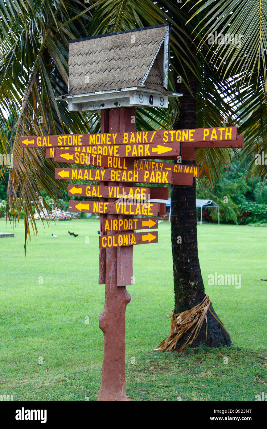 Holzpfosten mit den handgeschnitzten Zeigern verwendet als ein Straßenschild an der Kreuzung der beiden Straßen auf der Insel Yap in Mikronesien Stockfoto