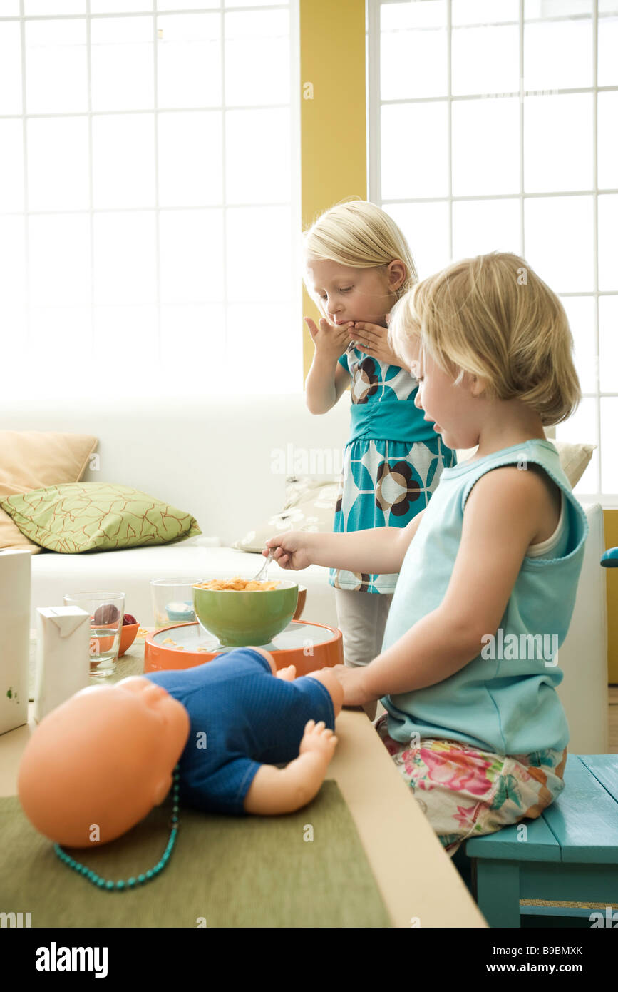 Kleine Mädchen essen Frühstück an unordentlich Tisch Stockfoto